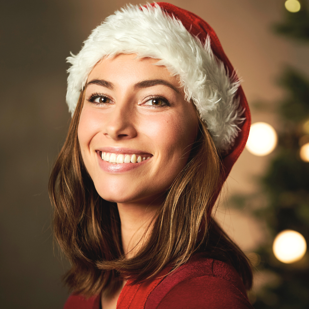 woman in a santa hat with glowing skin