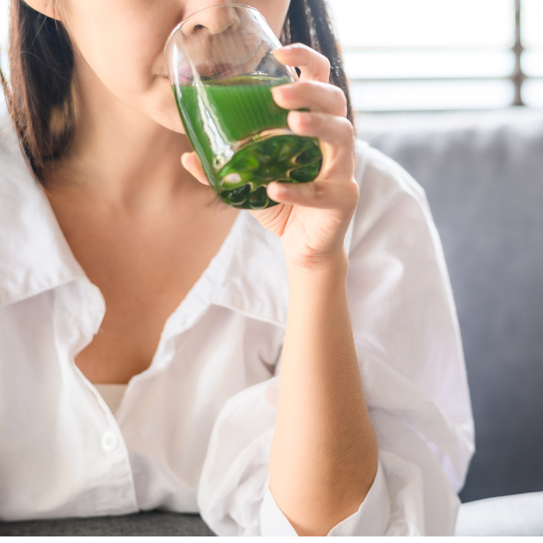 woman drinking green elixir