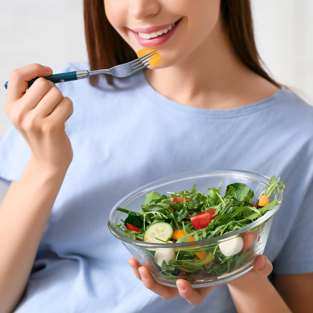 woman eating salad to support your liver